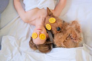 Female,And,Dog,Laying,In,Bed,With,Orange,Face,Mask